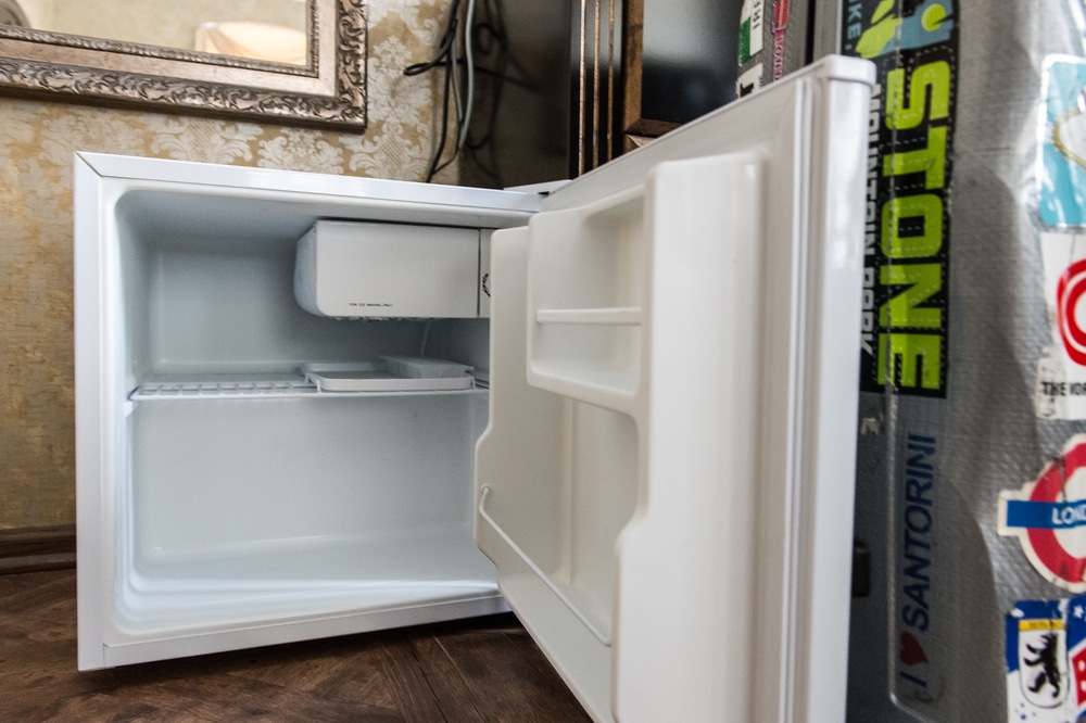An open mini fridge reveals a spotless interior
