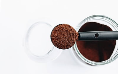 a spoonful of fine dark beans for a flavouful beverage