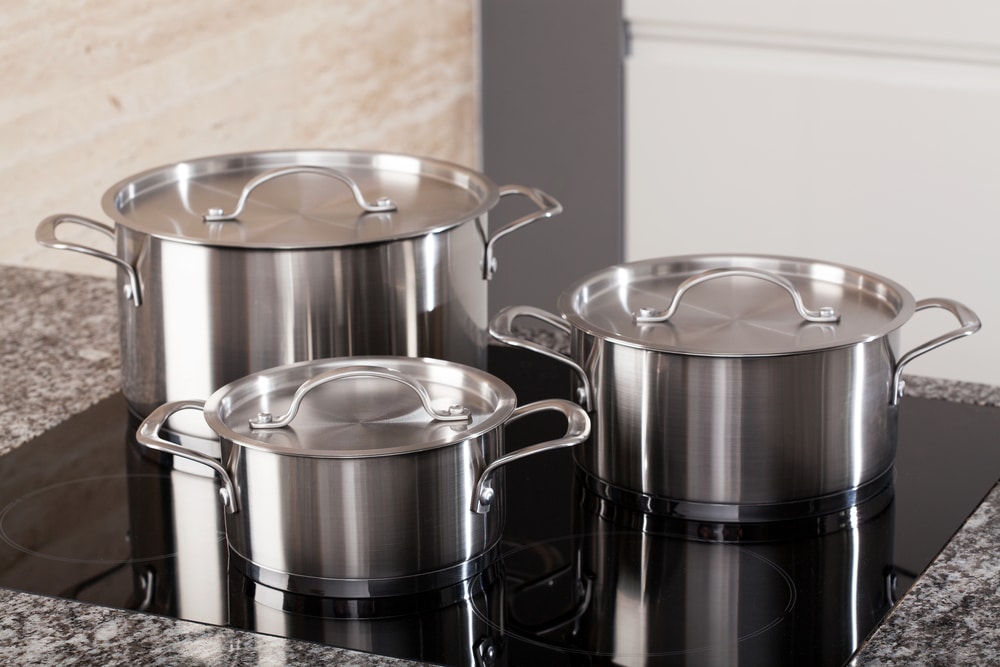 a-set-of-stainless-steel-cooking-pots-on-top-of-a-kitchen-counter